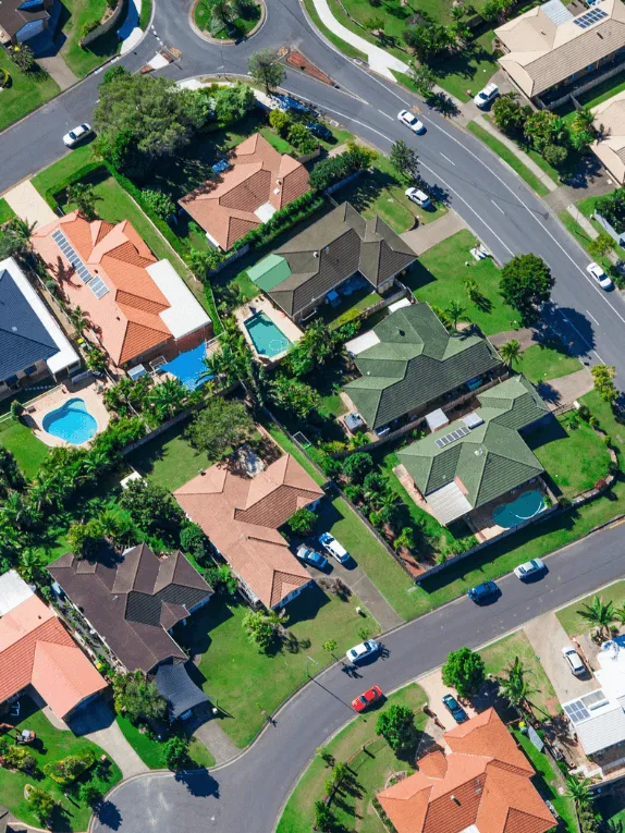 Home 3 Aerial view of a modern Australian suburban neighbourhood with single-storey homes, back-yard pools and tree-lined streets
